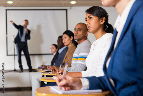 Free Download Portrait of interested hispanic female entrepreneur sitting in conference hall at business event. Business and entrepreneurship development concept.. - GFXLoad