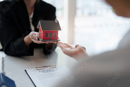 Close up Business woman or Real Estate agent explain signing agreement for buying house. Bank manager and real estate concept.