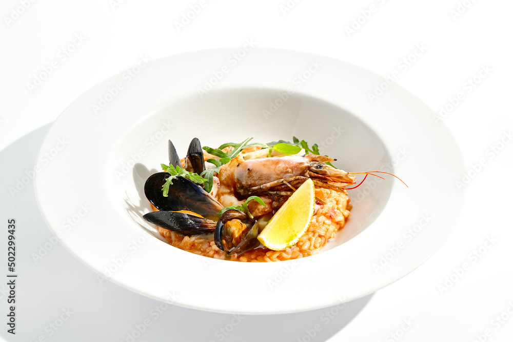 Italian dish - seafood risotto on white plate. Risotto frutti di mare with shrimp, mussels and squid. Seafood in marinara sauce with arborio rice. Paella with prawn and mussels. Seafood menu. Italian dish - seafood risotto on white plate. Risotto frutti di mare with shrimp, mussels and squid. Seafood in marinara sauce with arborio rice. Paella with prawn and mussels. Seafood menu.