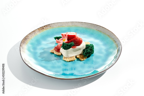 Italian dessert panna cotta with strawberry and berry sauce on biscuit. Concept summer dessert from cream jelly and berries. Panna cotta with fresh strawberry isolated on white background.