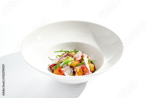 Roast beef and grilled vegetables salad isolated on white background. Steak salad with pastrami, eggplant, tomato, remoulade sauce with parmesan flakes. Gourmet dish with grilled meat