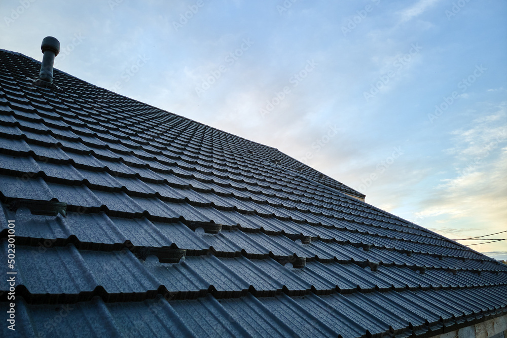 Snow guard for safety in winter on house roof top covered with ceramic shingles. Tiled covering of building Snow guard for safety in winter on house roof top covered with ceramic shingles. Tiled covering of building