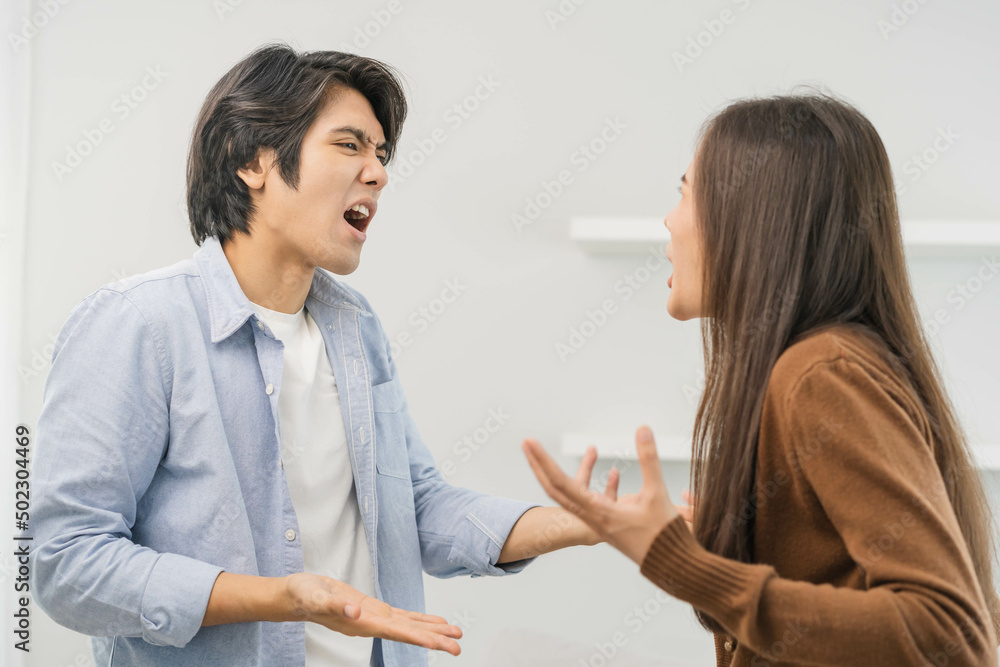Asian young couple fight standing on white background, relationship in trouble. Different angry, use emotion shouting at each other. Argue husband has expression of disappointment and upset with wife. Asian young couple fight standing on white background, relationship in trouble. Different angry, use emotion shouting at each other. Argue husband has expression of disappointment and upset with wife.