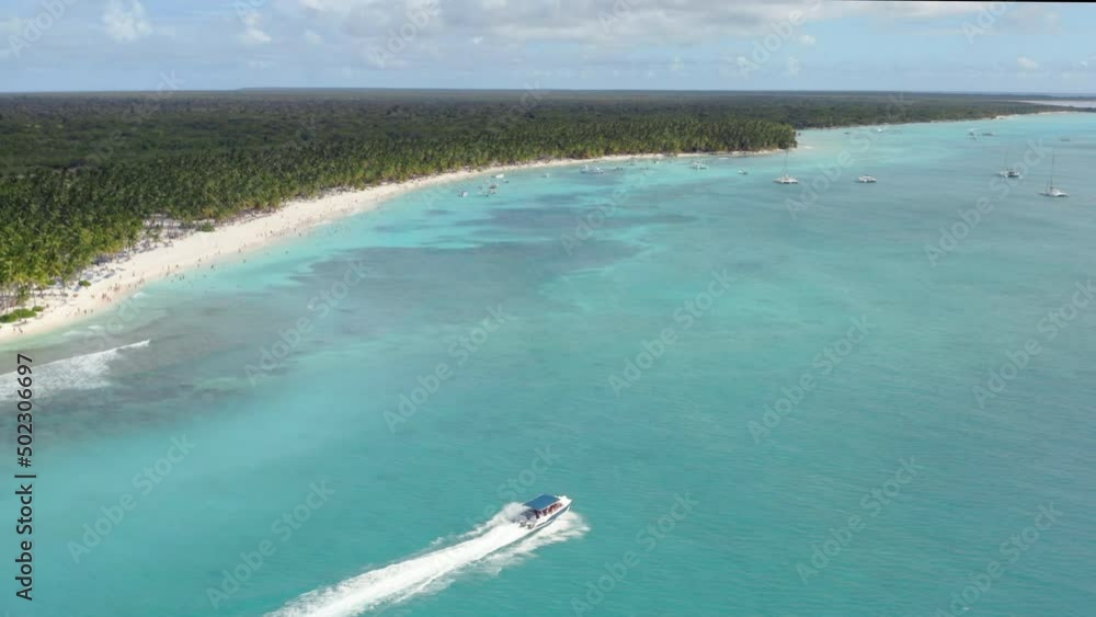 A powerboat cruises across tropical azure waters, the Dominican Republic, Aerial panorama reveal A powerboat cruises across tropical azure waters, the Dominican Republic, Aerial panorama reveal