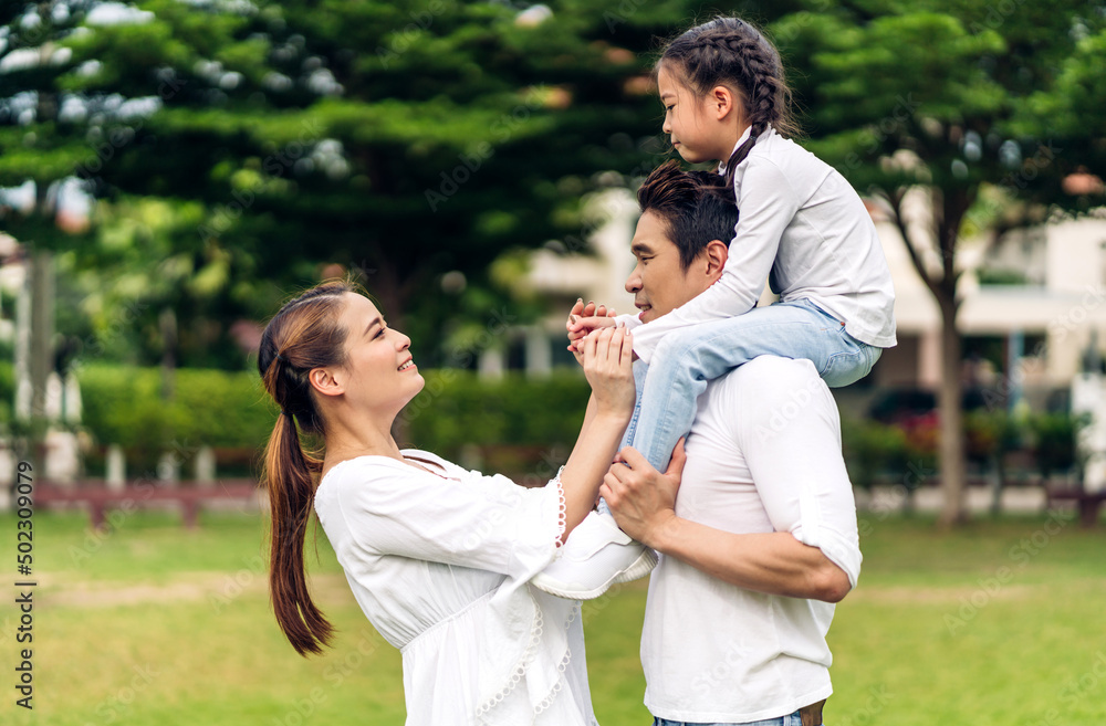 Portrait of enjoy happy love asian family father and mother holding hug cute little asian girl child smiling play and having fun moments good time in summer park at home Portrait of enjoy happy love asian family father and mother holding hug cute little asian girl child smiling play and having fun moments good time in summer park at home
