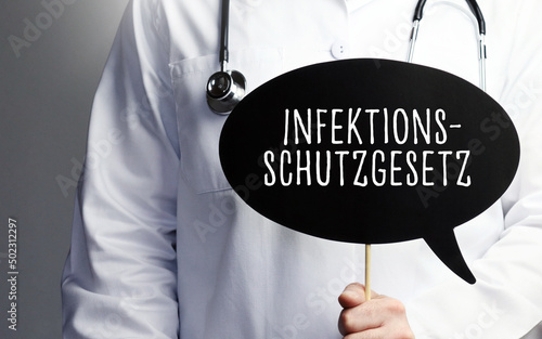 Infektionsschutzgesetz (IfSG). Arzt mit Stethoskop hält Sprechblase in Hand. Text steht im Schild. Gesundheitswesen, Medizin photo