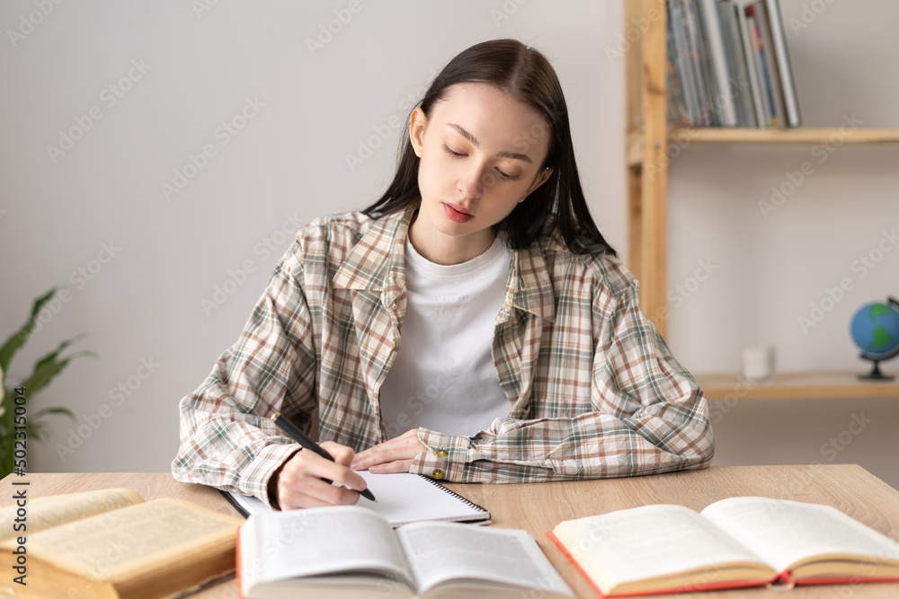 focused motivated girl college student studying with books, home education, doing homework, education focused motivated girl college student studying with books, home education, doing homework, education