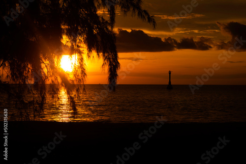 Beautiful sunset over the sea on tropical beach with  tree and boat observation point