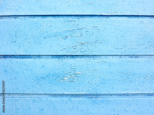 Bright blue painted wooden planks close up, detail of an old Mediterranean house door. Space for your text or logo.
