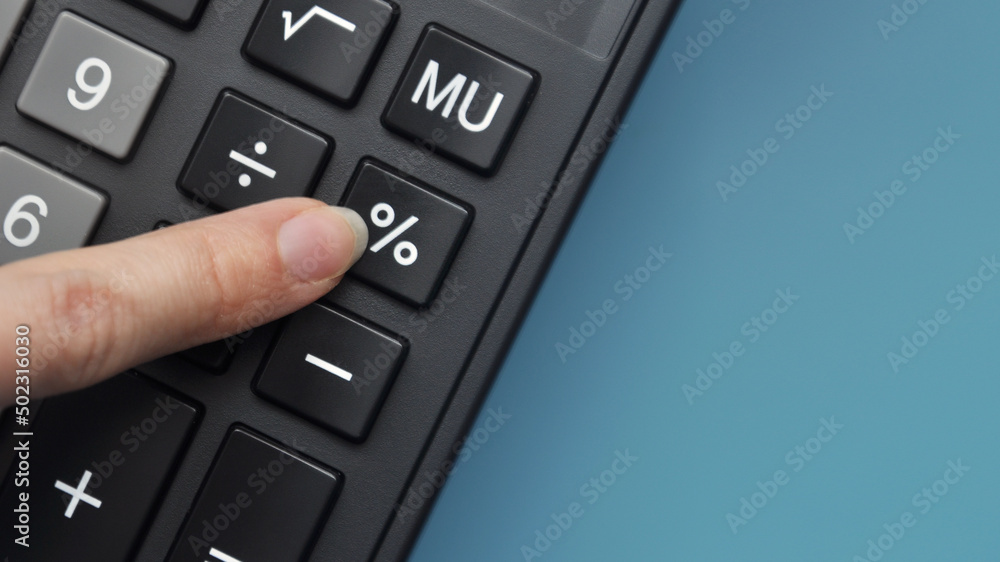 The person clicks on the percent button on the calculator. Profit and loss calculation symbol The person clicks on the percent button on the calculator. Profit and loss calculation symbol
