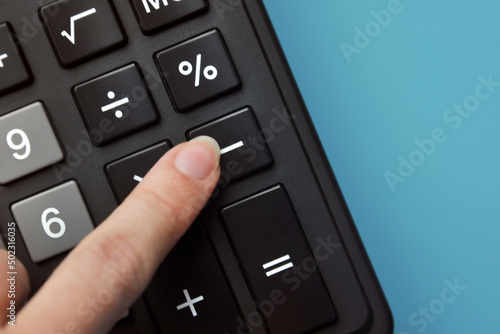 Tableau sur toile A person presses a minus sign on the calculator