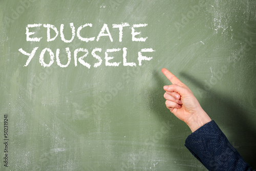 Canvas-taulu Educate Yourself. Woman points finger at text. Green chalk board