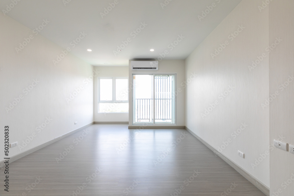Bright empty interior with two large window, city view and blank gray wall.