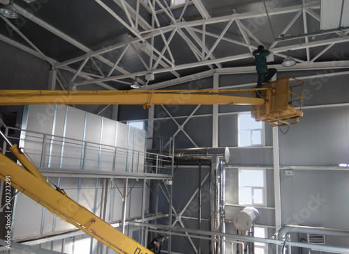 Scissor lift platform with hydraulic system with construction workers, Mobile aerial work platform with hydraulic system elevated towards, Mobile aerial work platform