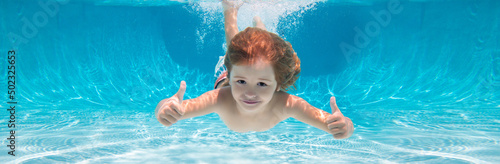 Canvas Print Child swimming underwater with thumbs up