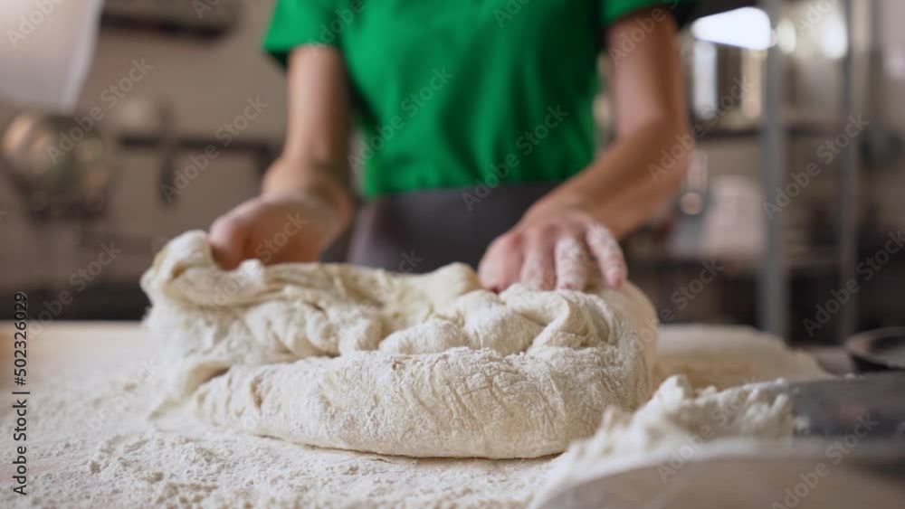 Close up view of baker hands kneading the dough on the table. Making bread, bread production. Close up view of baker hands kneading the dough on the table. Making bread, bread production.