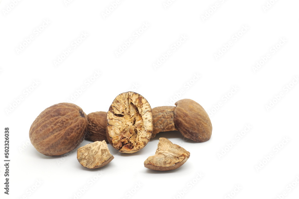Dried whole and cracked nutmeg seeds or Myristica fragrans spice isolated on white background. Dried whole and cracked nutmeg seeds or Myristica fragrans spice isolated on white background.