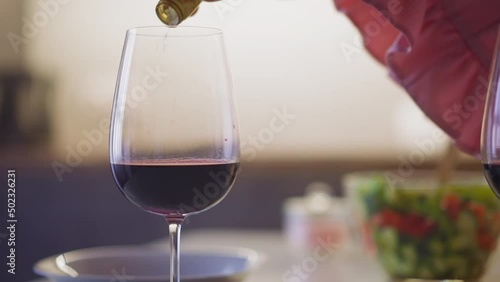 Perfidious woman pours rat poison white powder into hated person glass with wine to revenge during dinner in kitchen slow motion closeup