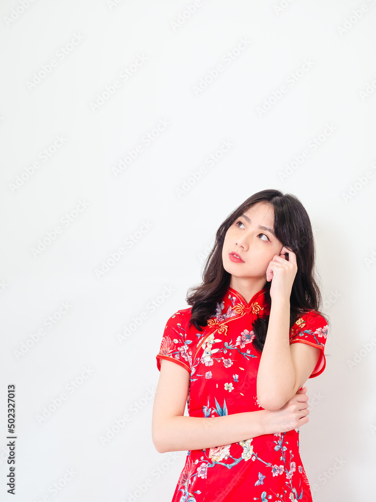 Portrait of Young asian woman wearing traditional cheongsam qipao dress thinking with hand on head isolated over white background. Portrait of Young asian woman wearing traditional cheongsam qipao dress thinking with hand on head isolated over white background.