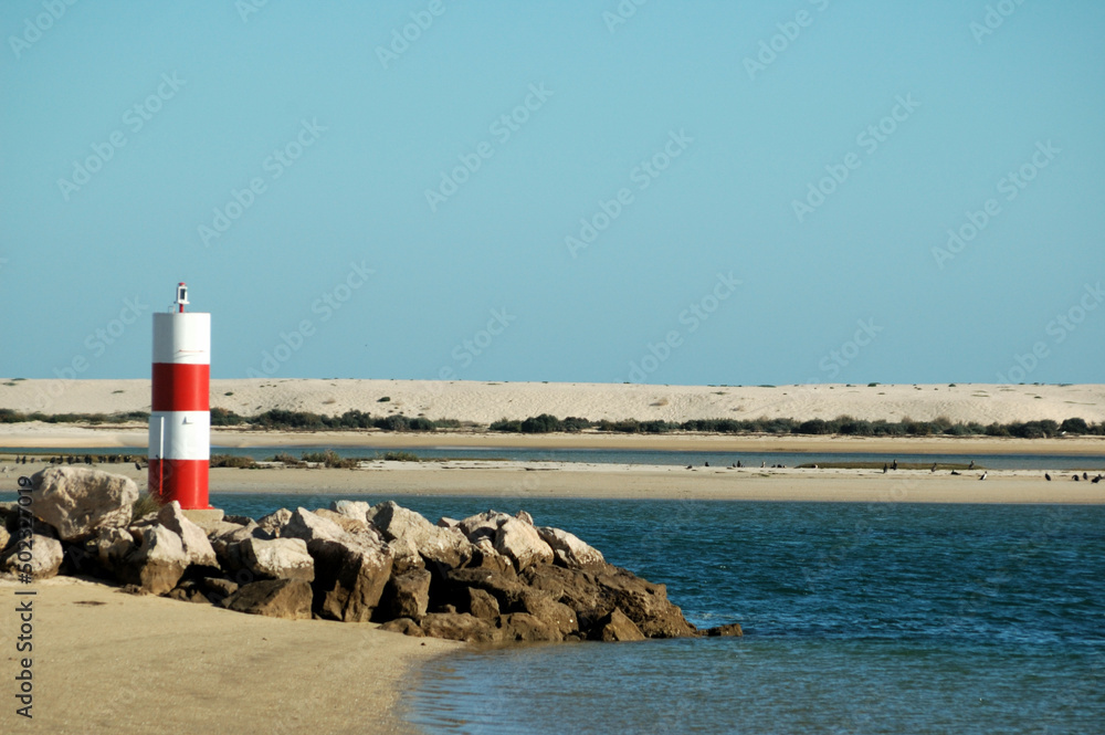 Small light tower at the harbor entrance in Fuseta, Algarve - Portugal Small light tower at the harbor entrance in Fuseta, Algarve - Portugal