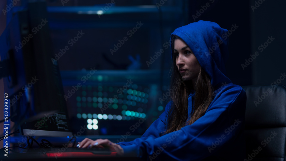 Young woman hacker by computer in the dark room at night, cyberwar concept. Young woman hacker by computer in the dark room at night, cyberwar concept.