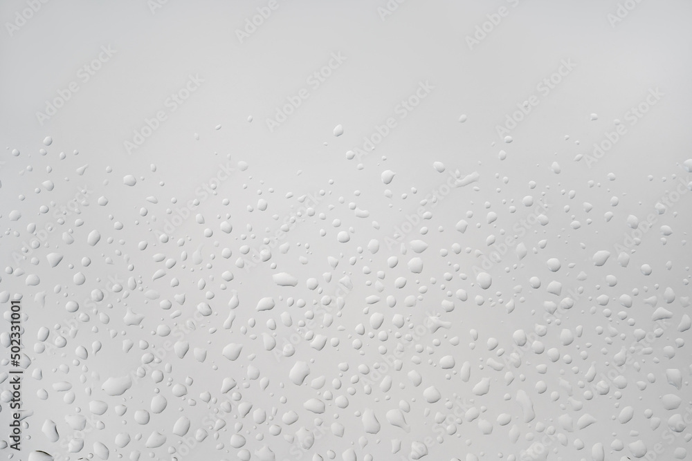 perfect backlit chaotic water drops on white light glass background. Natural hydration
