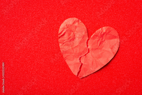 Bild auf Leinwand Red paper heart torn apart on two pieces on red background
