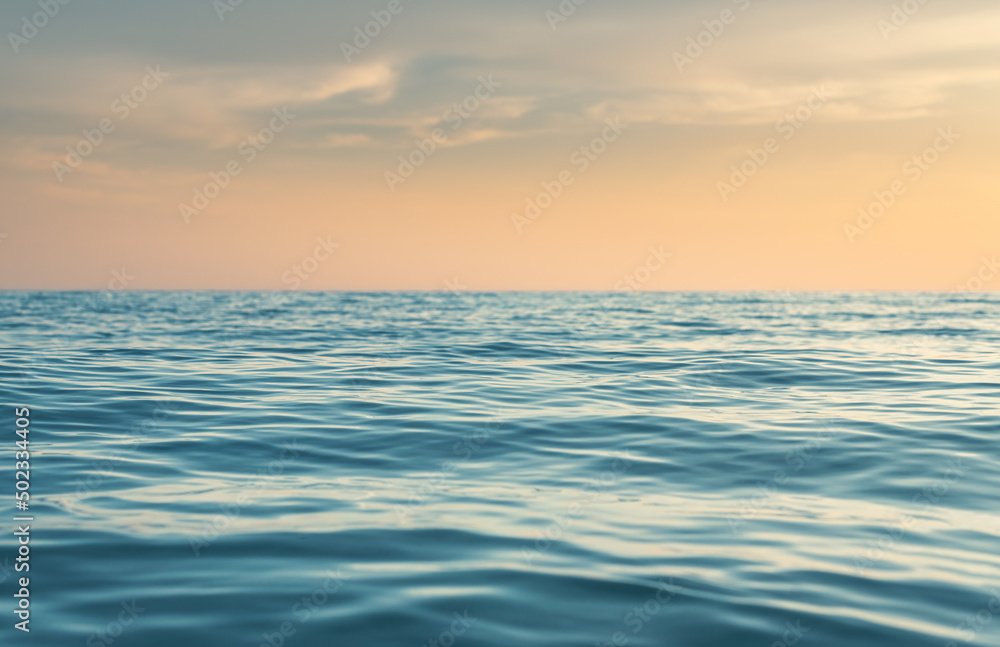 Fototapeta premium amazing shot of a calm blue sea on orange sunset background. Landscape Seascape, Amazing beach scene vacation and summer holiday concept. Luxury travel. background and copy space. Sea travel holiday.