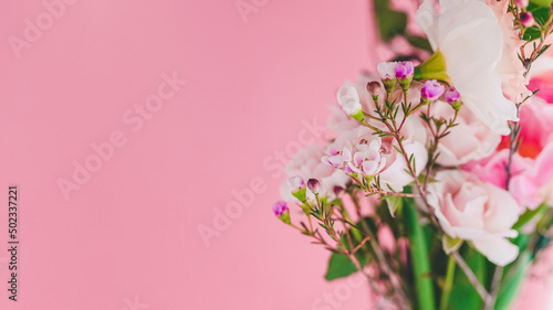 Chamelacium hookata, roses and daffodils in a bouquet on a pink background close-up, copy space photo