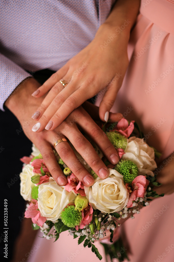 Touching hands of groom and bride near bouquet of flowers. Wedding day concept. Wedding picture. Love is. Touching hands of groom and bride near bouquet of flowers. Wedding day concept. Wedding picture. Love is.