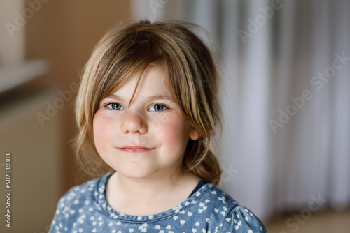 Close-up portrait of a cute little girl. Happy smiling preschool child looking at the camera. Childhood concept.