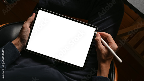 A digital tablet touchpad white screen mockup is on a male hands.