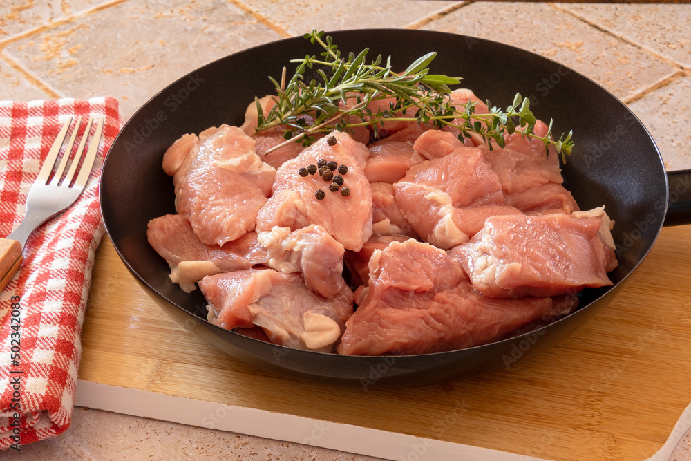 piece of raw veal in a frying pan on a wooden board piece of raw veal in a frying pan on a wooden board