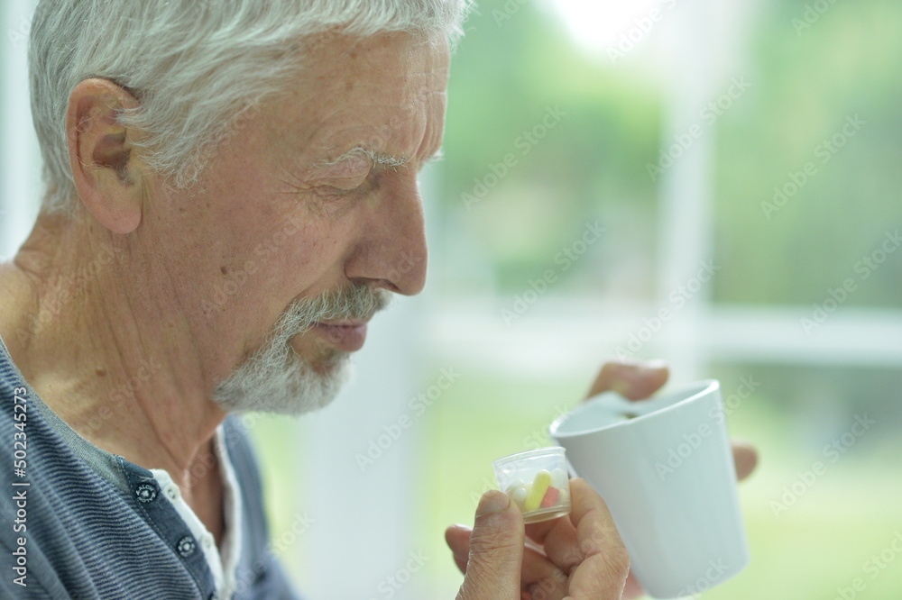 Portrait of sad sick senior man with pills Portrait of sad sick senior man with pills
