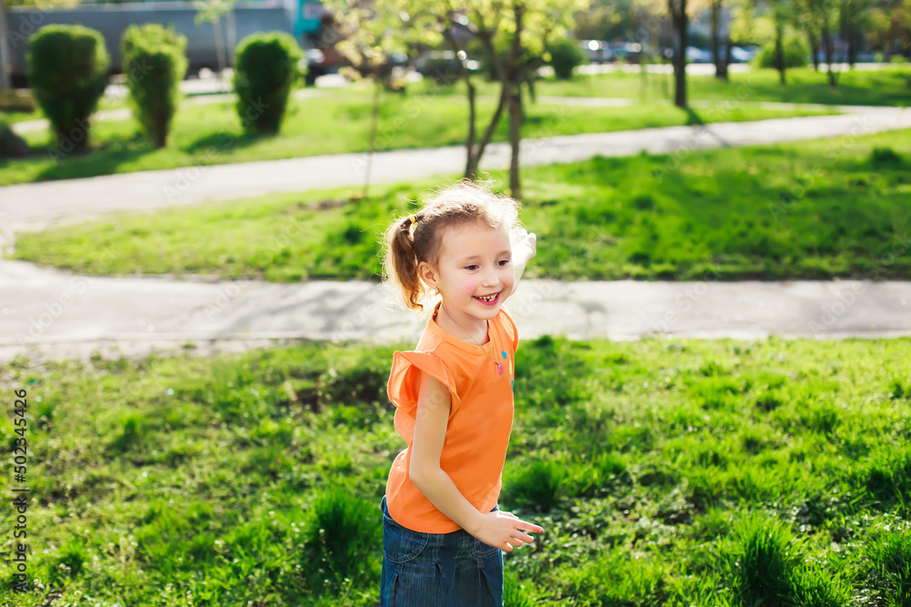The little girl laughs. Girl running on green grass in the spring. The child's teeth fall out. Girl with two tails on the head. The little girl laughs. Girl running on green grass in the spring. The child's teeth fall out. Girl with two tails on the head.