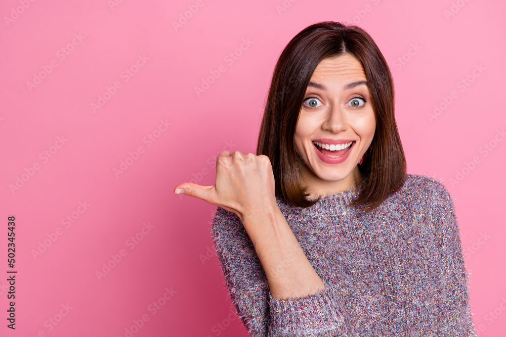 Photo of impressed cute woman wear pullover pointing empty space isolated pink color background Photo of impressed cute woman wear pullover pointing empty space isolated pink color background