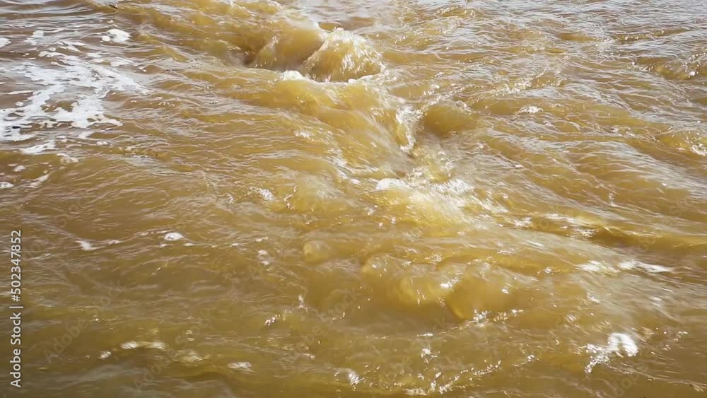 Muddy river water. Spring flood. Dirty muddy water with whirlpool and white foam. Muddy river water. Spring flood. Dirty muddy water with whirlpool and white foam.
