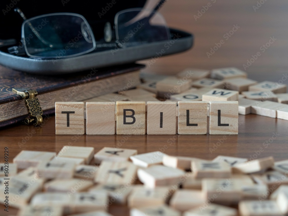 t bill word or concept represented by wooden letter tiles on a wooden table with glasses and a book t bill word or concept represented by wooden letter tiles on a wooden table with glasses and a book