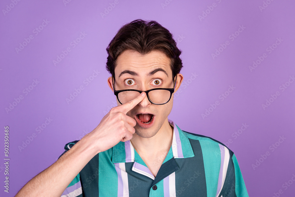Photo of young man finger touch eyeglasses astonished stupor fake information isolated over violet color background
