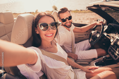 Self-portrait of attractive cheerful couple riding car spending free time weekend fresh air relax outdoors © deagreez