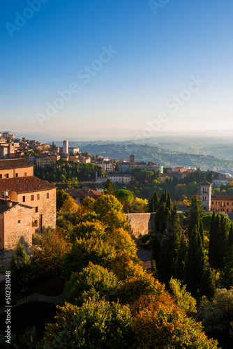 Perugia old skyline at sunset with medieval churches and towers and Umbria countryside with mist just before sunset
