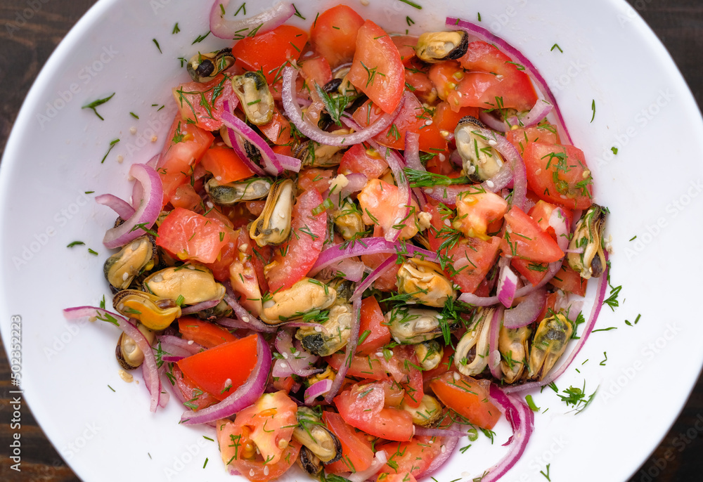 Salad with mussels and tomatoes and red onion in white plate. Concept of healthy diet food. Flat lay. Salad with mussels and tomatoes and red onion in white plate. Concept of healthy diet food. Flat lay.