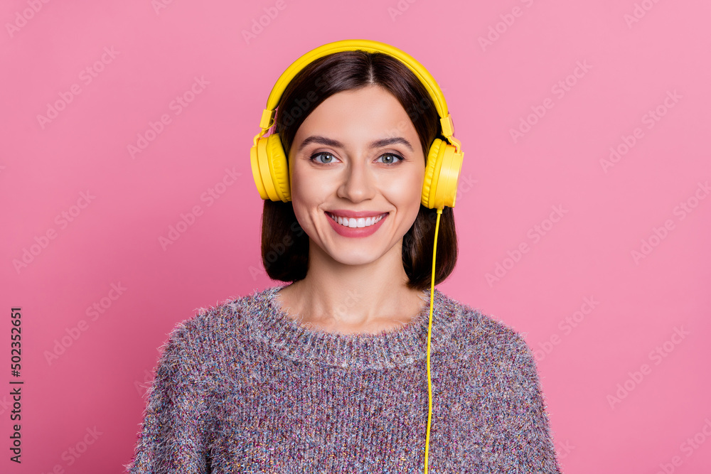 Photo of adorable shiny woman wear pullover yellow headphones smiling isolated pink color background Photo of adorable shiny woman wear pullover yellow headphones smiling isolated pink color background