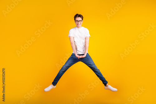 Full size photo of young man have fun jump up active energetic fly isolated over yellow color background