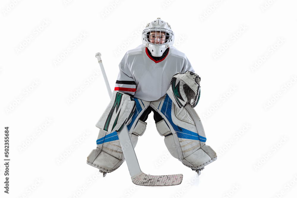 Fototapeta premium Full-length portrait of boy, hockey player, goalkeeper training, playing isolated over white studio background