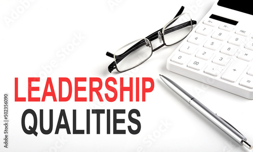LEADERSHIP QUALITIES Concept. Calculator,pen and glasses on white background photo