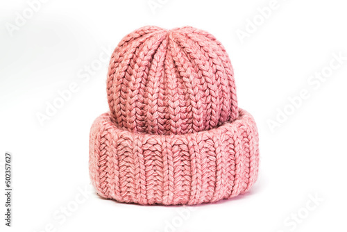 Knitted from wool winter women's hat of pink color isolated on a white background.