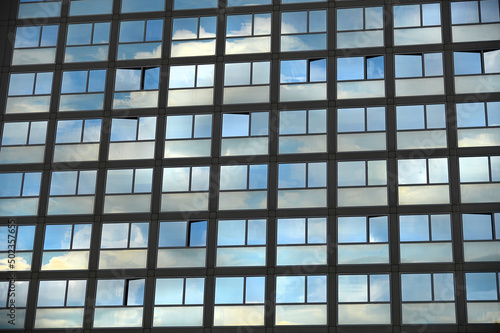 cloudy sky reflection on glass surface of modern building