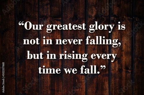 “Our greatest glory is not in never falling, but in rising every time we fall.”  Inspirational quote on vintage retro background. Ancient Chinese philosopher Confucius quote.