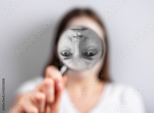 Distorted self perception or image concept. Woman face inverted at magnifying glass. Psychology problems and poor, unstable sense of who you are. High quality photo photo